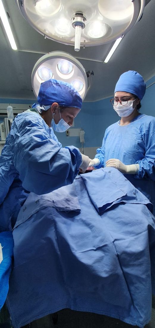Dra. Maria Angélica em cirurgia, paramentada na sala cirúrgica
